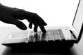 Silhouette of a female hands typing on the keyboard of the netbook Royalty Free Stock Photo