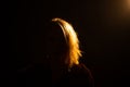 Silhouette of a female portrait. An unrecognizable woman looks into the frame. Dark background. Mystery, incognito concept