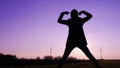 Silhouette of a female posing against the purple sky at sunset - confidence and strength concept Royalty Free Stock Photo