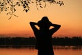 Silhouette of a female relaxing on the waterfront at dusk Royalty Free Stock Photo