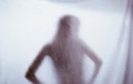 Silhouette of a female sexual figure behind foggy glass. concept of the spirit of poltergeist from the other world. frightening