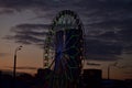 Silhouette of a Ferris wheel against the sunset sky with clouds Royalty Free Stock Photo