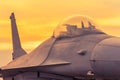 Fighter jet military aircraft parked on runway in sunset time