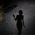 Silhouette of the figure of a young girl in the rain, happy young woman holding an umbrella that blows away Royalty Free Stock Photo