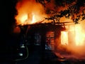 Silhouette firefighter in front of a burning scout cabin