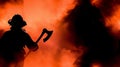 Silhouette of firefighter wielding axe in fiery blaze Royalty Free Stock Photo