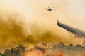 Silhouette firefithing helicopter dumps water on forest fire Royalty Free Stock Photo