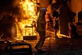 Silhouette of fireman trying to control a fire in a street during a night