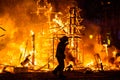 Silhouette of fireman trying to control a fire in a street during a night