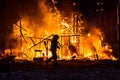 Silhouette of fireman trying to control a fire in a street during a night