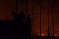 Silhouette of Firemen fighting a raging fire