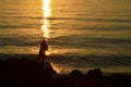 Silhouette of a fisher on sea cliff at the sunrise Royalty Free Stock Photo