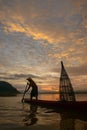 Silhouette fisherman of Bangpra Lake in action when fishing. Royalty Free Stock Photo