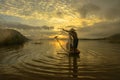 Silhouette fisherman of Bangpra Lake in action when fishing, Royalty Free Stock Photo