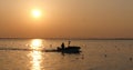 Silhouette of fisherman in a boat on the Beautiful sunset on the sea or river Royalty Free Stock Photo