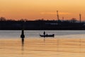 Silhouette of the fisherman in the boat fishing in river on sunset Royalty Free Stock Photo