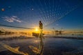 Silhouette of fisherman cast their nets to catch fish in the morning