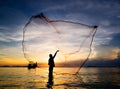 Silhouette of fisherman casting fishing net into the sea Royalty Free Stock Photo