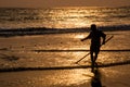 Silhouette of fisherman catching fish in sea by using fishing net at sunset time Royalty Free Stock Photo