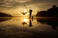 Silhouette of fisherman is fishing in the Lake during sunrise at Baan Nong Thale in Krabi