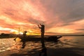 Silhouette Fisherman Fishing by using Net on the boat in morning Royalty Free Stock Photo