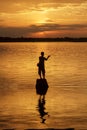 Silhouette fisherman of Lake in action when fishing. Royalty Free Stock Photo