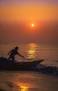 Silhouette of Fisherman pulling his boat in sea beach during early morning Sunrise time on a travel for refreshing mind and SOUL. Royalty Free Stock Photo