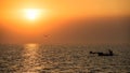 Silhouette fisherman sailing boat at sunset