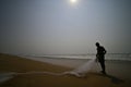 Silhouette of fisherman on the shore of Chandrabhaga beach, india.