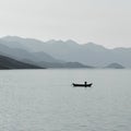 Silhouette of a fisherman in small boat in lake Royalty Free Stock Photo