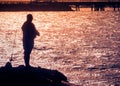 Silhouette of fisherman with sparkling sea water reflected Royalty Free Stock Photo