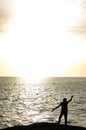 Silhouette fisherman stand on the edge of bridge Throwing Net to the Sea. Royalty Free Stock Photo