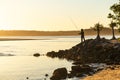 Silhouette of Fisherman Standing on the Edge of River Shore at Sunset Time. Nature Sport Concept Royalty Free Stock Photo