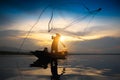 Silhouette fisherman throwing fishing net during