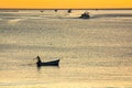 Silhouette of fishermen boat on Mediterranean Sea during sunrise in golden sun rays in MDiq, Morocco