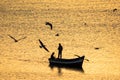 Silhouette of fishermen boat on Mediterranean Sea during sunrise in golden sun rays in Morocco Royalty Free Stock Photo