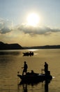 Silhouette of fishermen on dam water