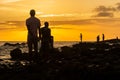 Silhouette of fishermen fishing on top of rocks at beach