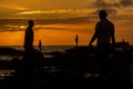 Silhouette of fishermen fishing on top of rocks at beach