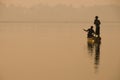 Silhouette of fishermen in the golden morning light with a foot rower, on the Taungthaman Lake in myanmar Royalty Free Stock Photo