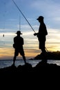Silhouette of fishermen on the rocks of the Rio Vermelho beach in Salvador, Bahia, fishing for their food and support for their