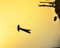 Silhouette of fishermen Take a small fishing boat to the river at sunset.yellow background Royalty Free Stock Photo
