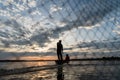 Silhouette of Fishermen throwing net fishing in sunset time at W Royalty Free Stock Photo