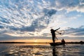 Silhouette of Fishermen throwing net fishing in sunset time at W Royalty Free Stock Photo