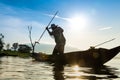 Silhouette of fishermen using coop-like trap catching fish in la