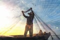 Silhouette of fishermen using coop-like trap catching fish in lake with beautiful scenery of nature morning sunrise. Beautiful