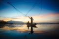 Silhouette of fishermen using nets to catch fish at the lake