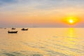 Silhouette of fishery boat in sea with sunset sky.