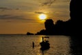 Silhouette of fishing boat and man at sunset on sea beach resort in Thailand, Krabi, Railey and Tonsai Royalty Free Stock Photo