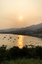 Silhouette of fishing boat, mountain and village